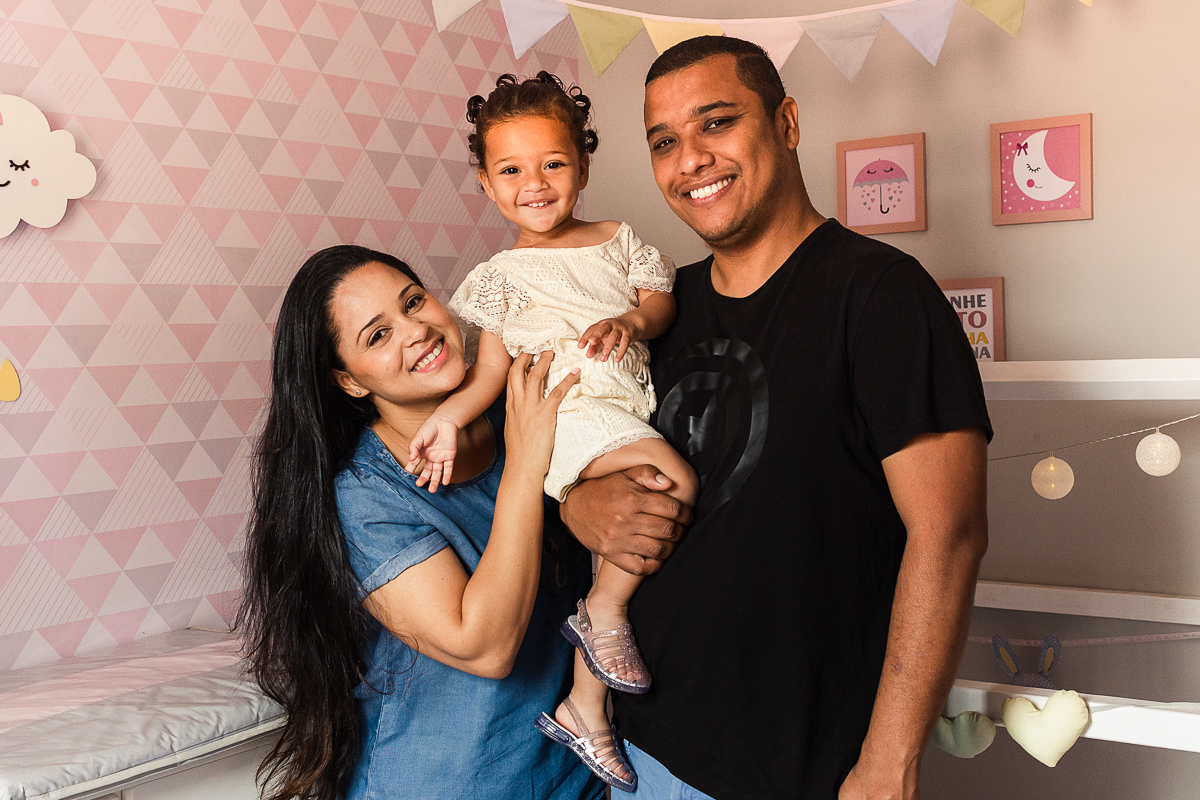 foto de família sorrindo dentro do quarto de menina com decoração rosa com decoração da boneca metoo baby, no ensaio lifestyle em casa na cidade de SP