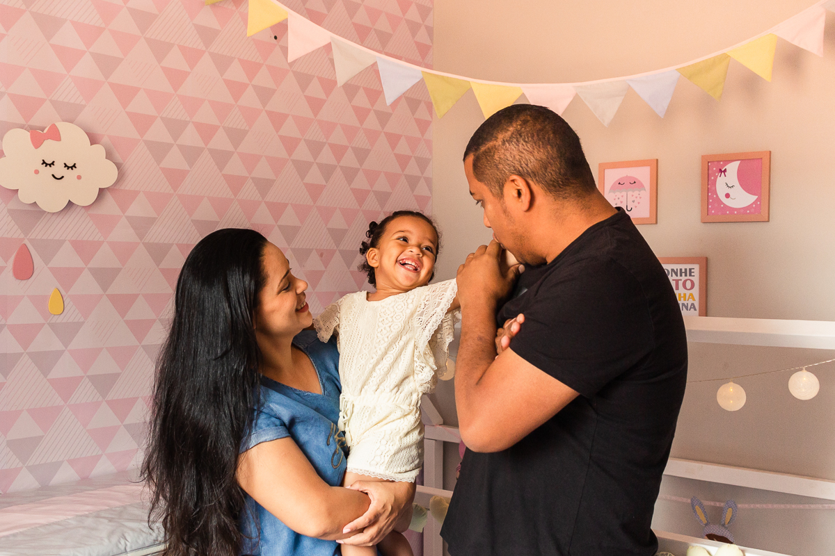 oto de família sorrindo dentro do quarto de menina com decoração rosa com decoração da boneca metoo baby, no ensaio lifestyle em casa na cidade de SP