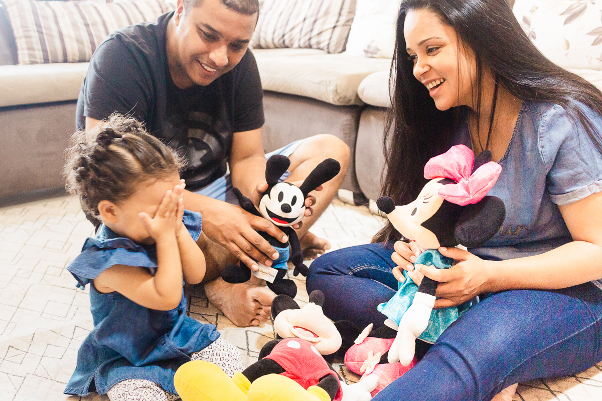 foto de família brincando com bonecos da Disney no chão da sala de casa  no ensaio lifestyle em casa na cidade de SP