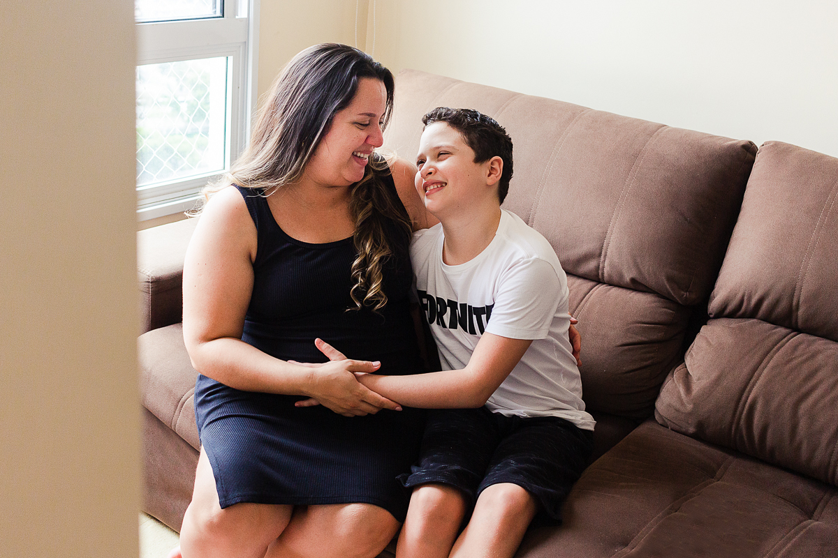 foto de mãe e filho abraçados com a mão na barriga de gravida no ensaio em Sp