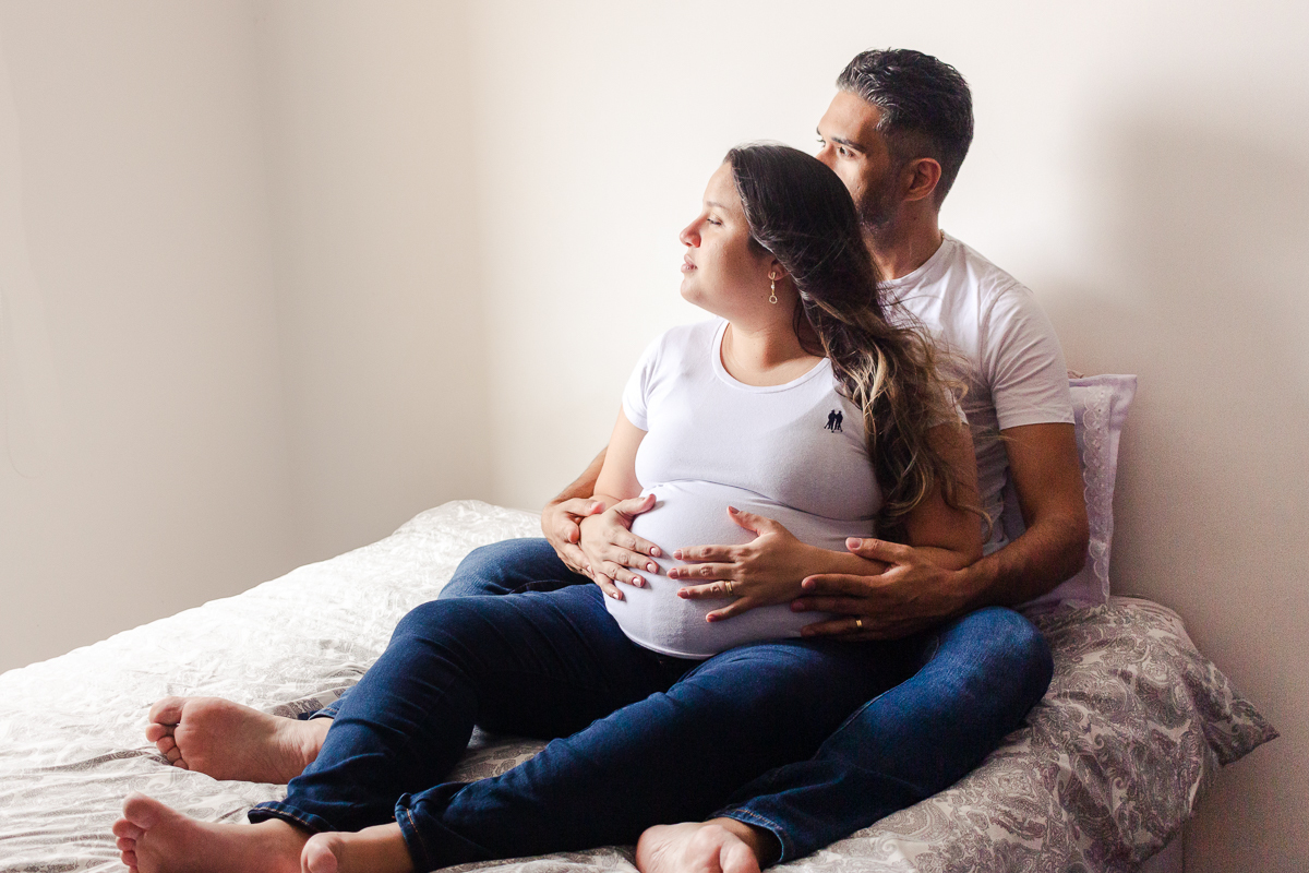 foto de casal abraçados com a mão na barriga de gravida no ensaio de gestante em Sp