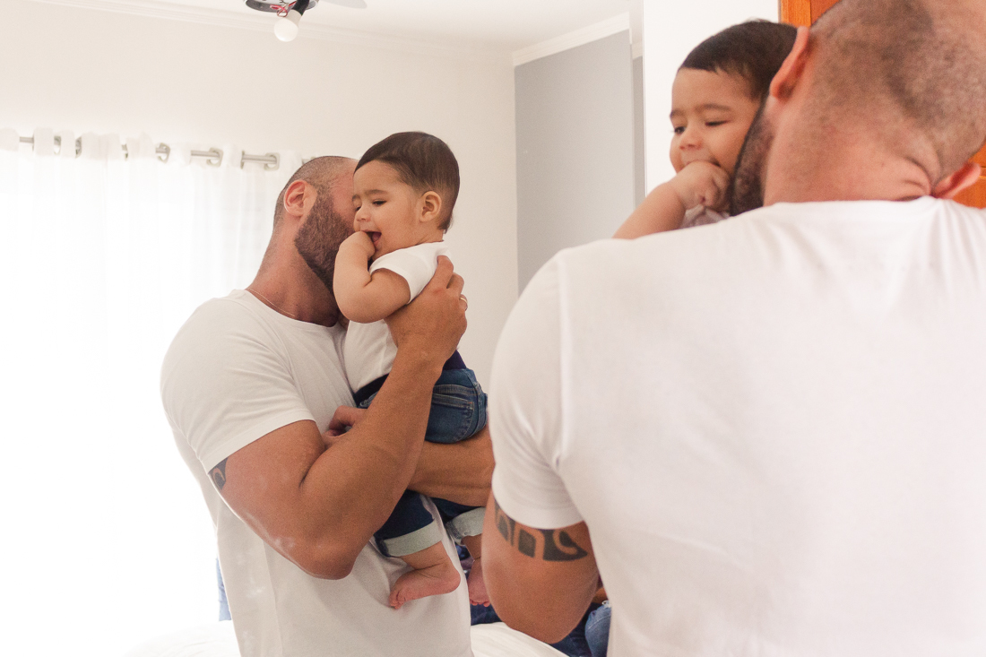 Foto de pai beijando filho dentro do quarto no ensaio lifestyle em Sp