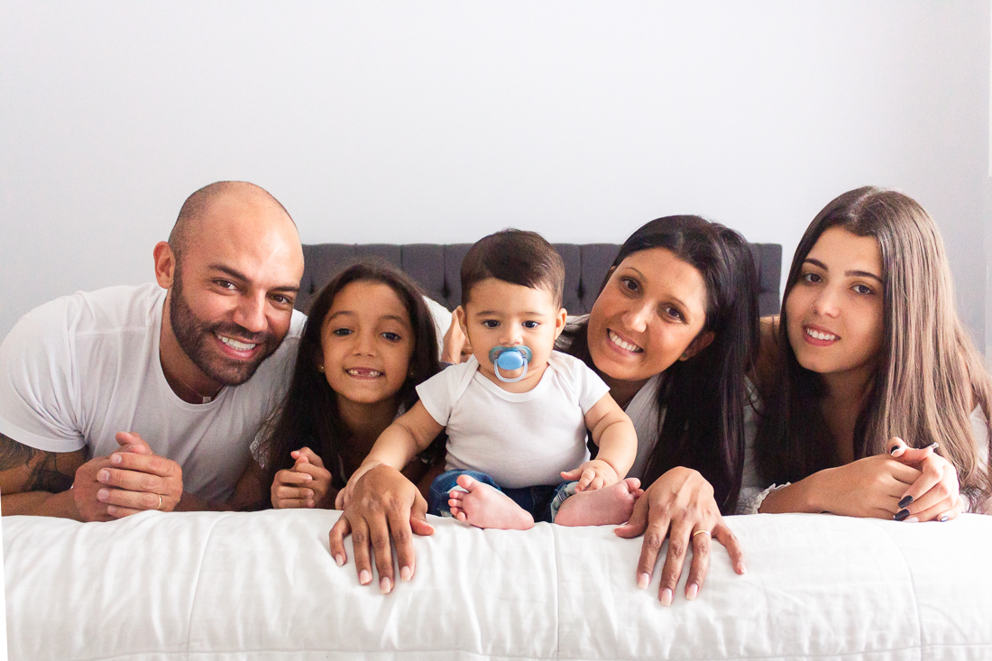 foto de família reunida no quarto deitados na cama sorrindo no ensaio lifestyle na cidade de Sp