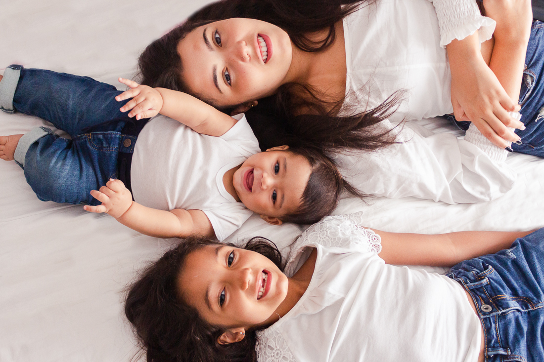 foto de irmãs e irmão deitado na cama no ensaio lifestyle de família no Jd Primavera na cidade de SP