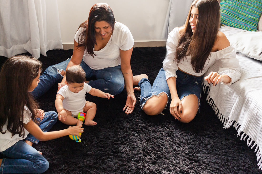 foto de família mãe e filhos sentados no chão da sala brincando no ensaio de familia na cidade de Sp