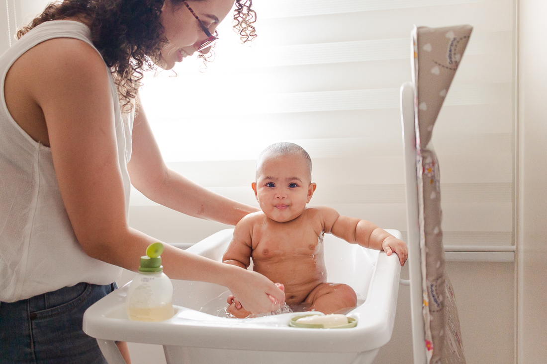 foto da mãe dando banho na filha no ensaio lifestyle de família em casa na zona leste de São Paulo