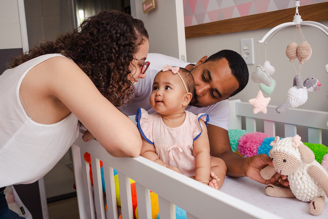 foto de bebe olhando para os pais dentro do berço no quarto de menina na cidade de Sp 