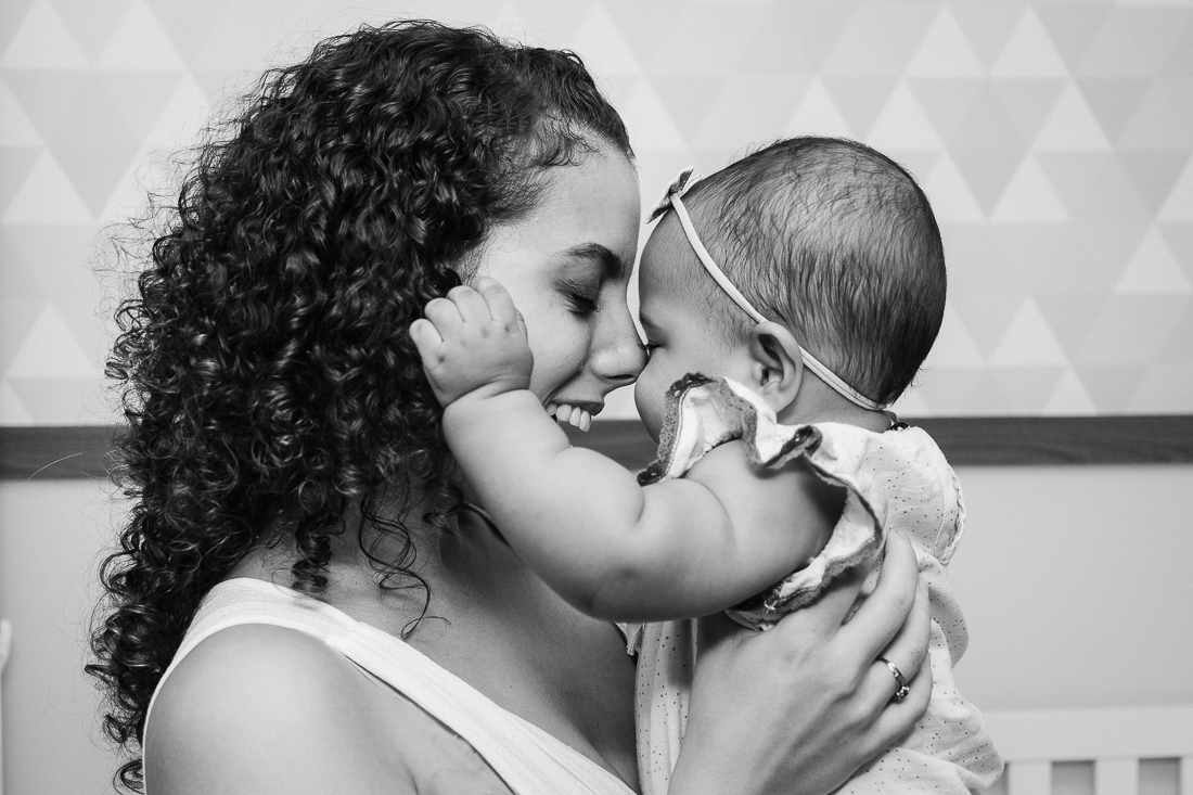 foto de mãe e filha fazendo carinho com rosto colado dentro do quarto de menina no ensaio de família na cidade de Sp 