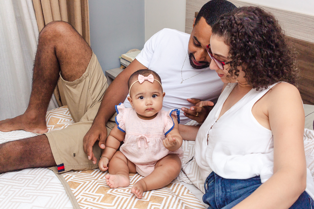 foto de pais com filha na cama no quarto no ensaio de família