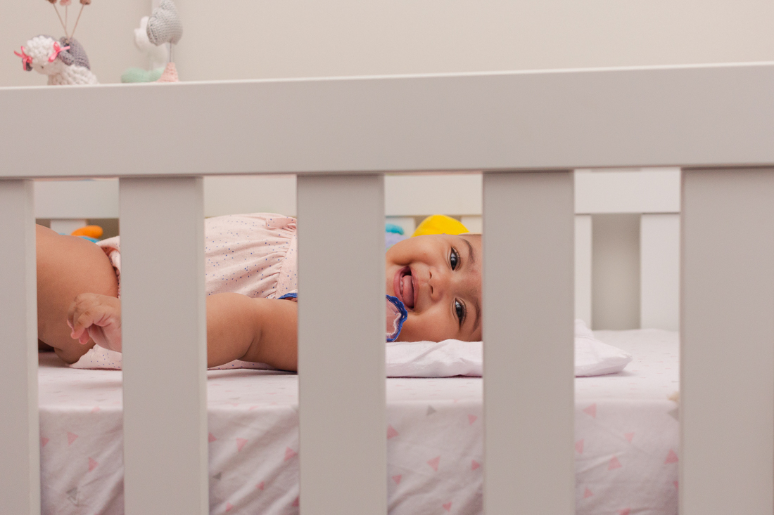 foto de criança deitada no berço no ensaio em casa na cidade de Sp