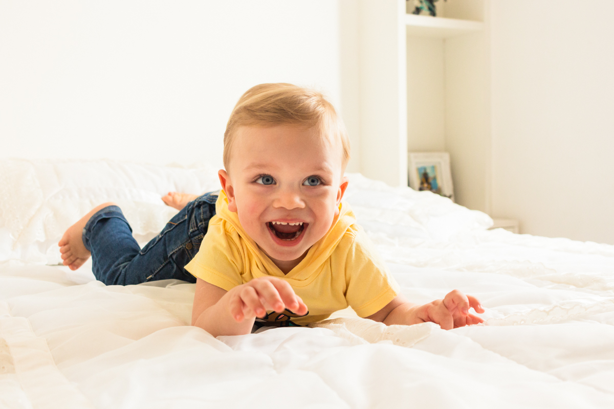 foto infantil de menino deitado na cama no ensaio de família em Itaquera na cidade de São Paulo