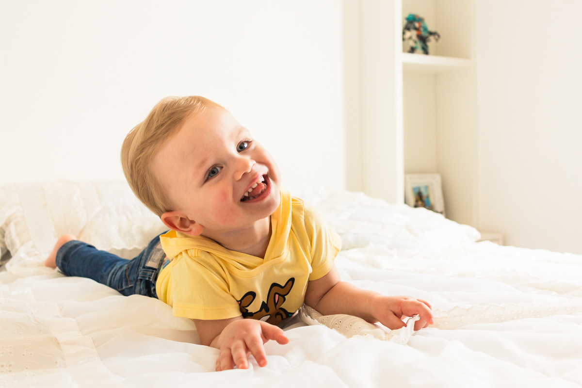 foto infantil de menino deitado na cama no ensaio de família em Itaquera na cidade de São Paulo