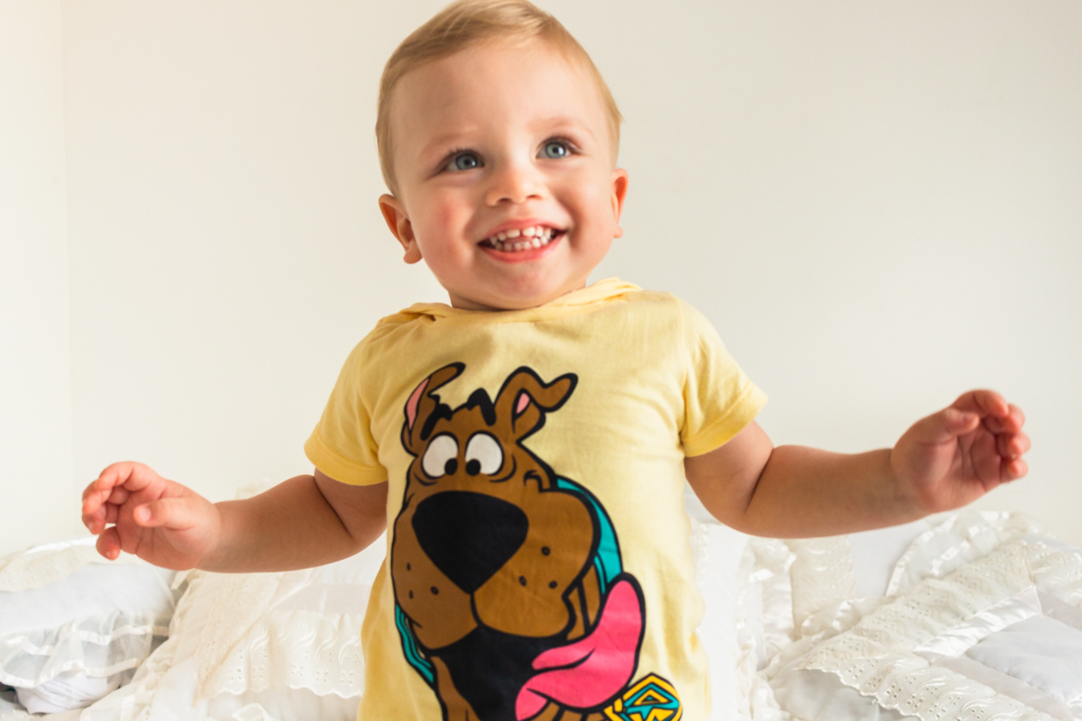 foto infantil de menino deitado na cama no ensaio de família em Itaquera na cidade de São Paulo