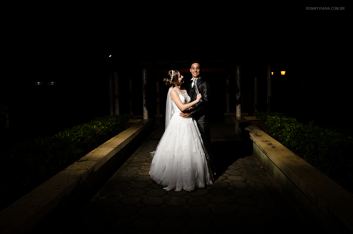 Noiva segurando na gravata do noivo e noivo fazendo cara engraçada