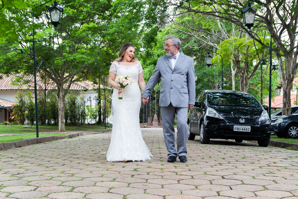 noiva caminhando com o pai em direção a porta da igreja