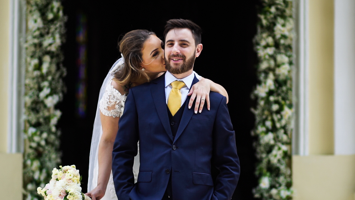 Noiva beijando pescoço do noivo