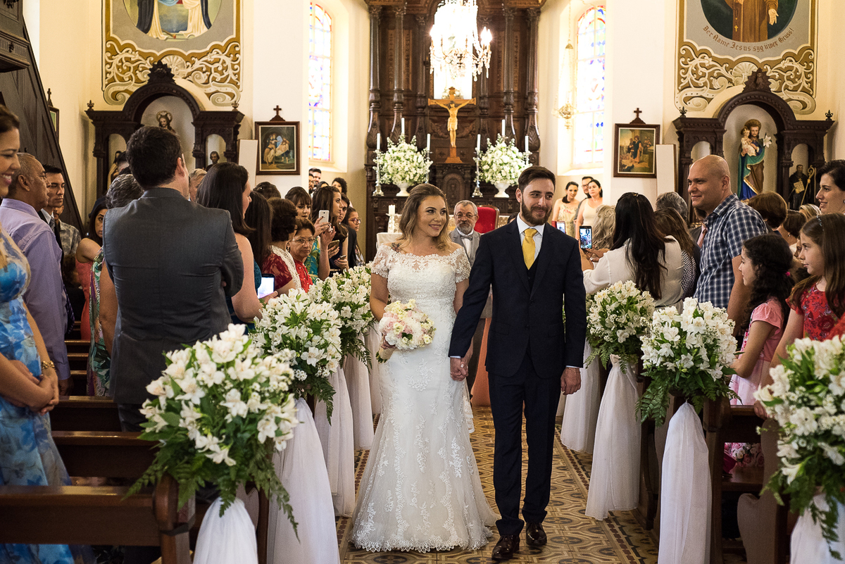Noivos saindo pelo corredor da igreja helvetia em indaiatuba