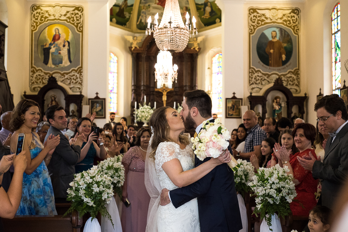 noivos se beijando na porta da igreja