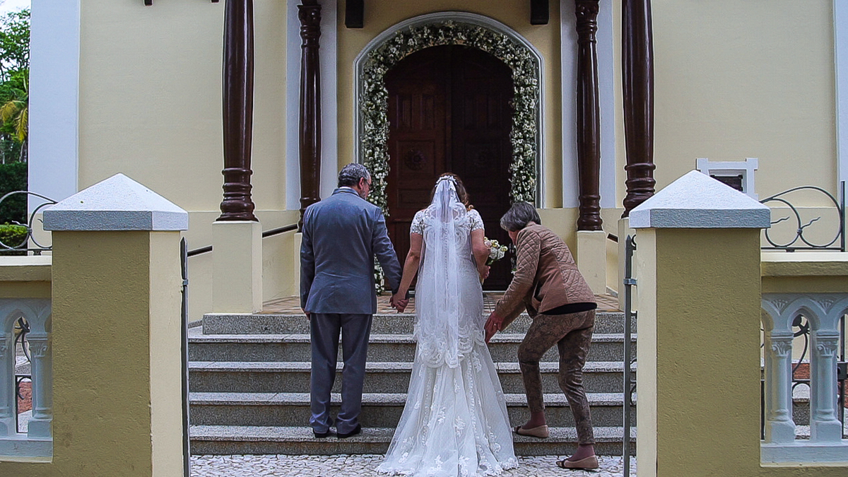 noiva subindo as escadas para entrar na igreja, cerimonialista ajudando 