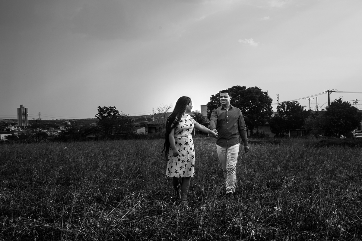 noiva puxando noivo pelas mãos em campo de trigo