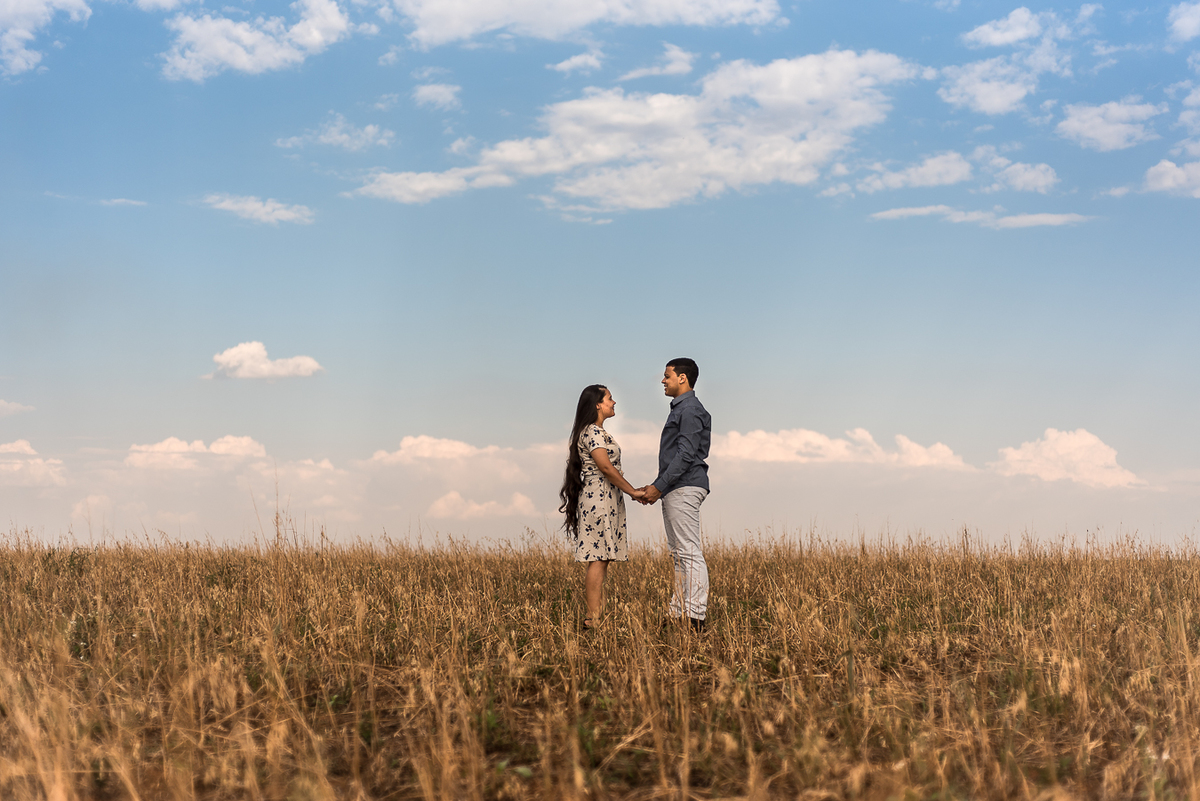 casal em campo de trigo com as mãos dadas