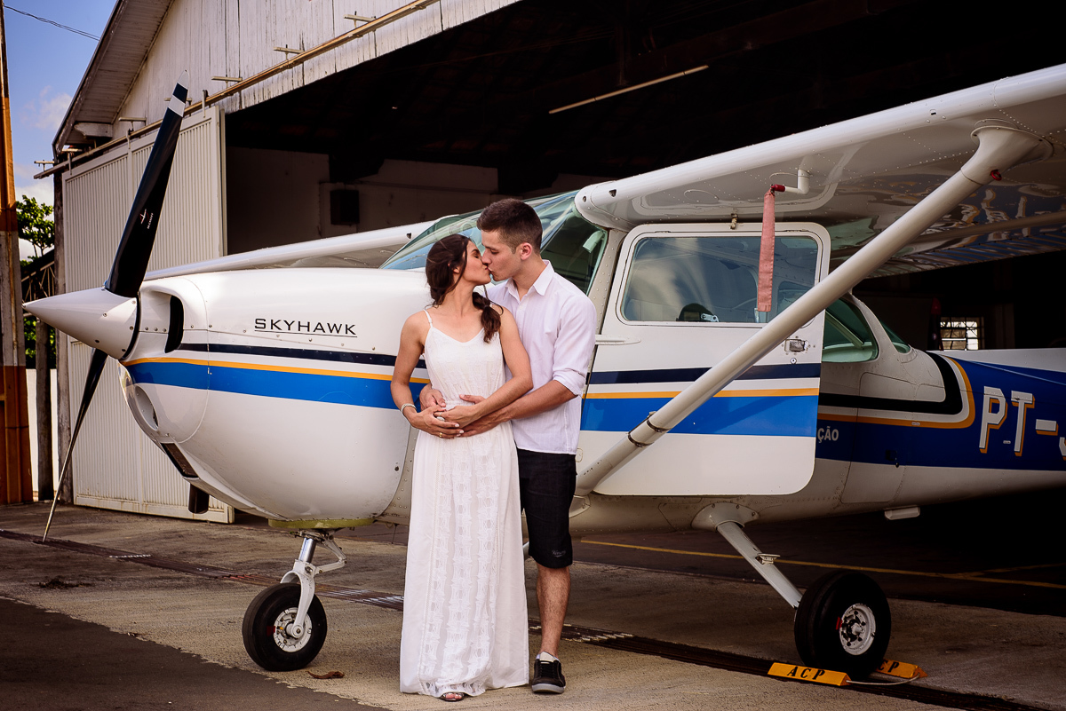 casal em frente ao avião roupas claras para ensaio pre casamento
