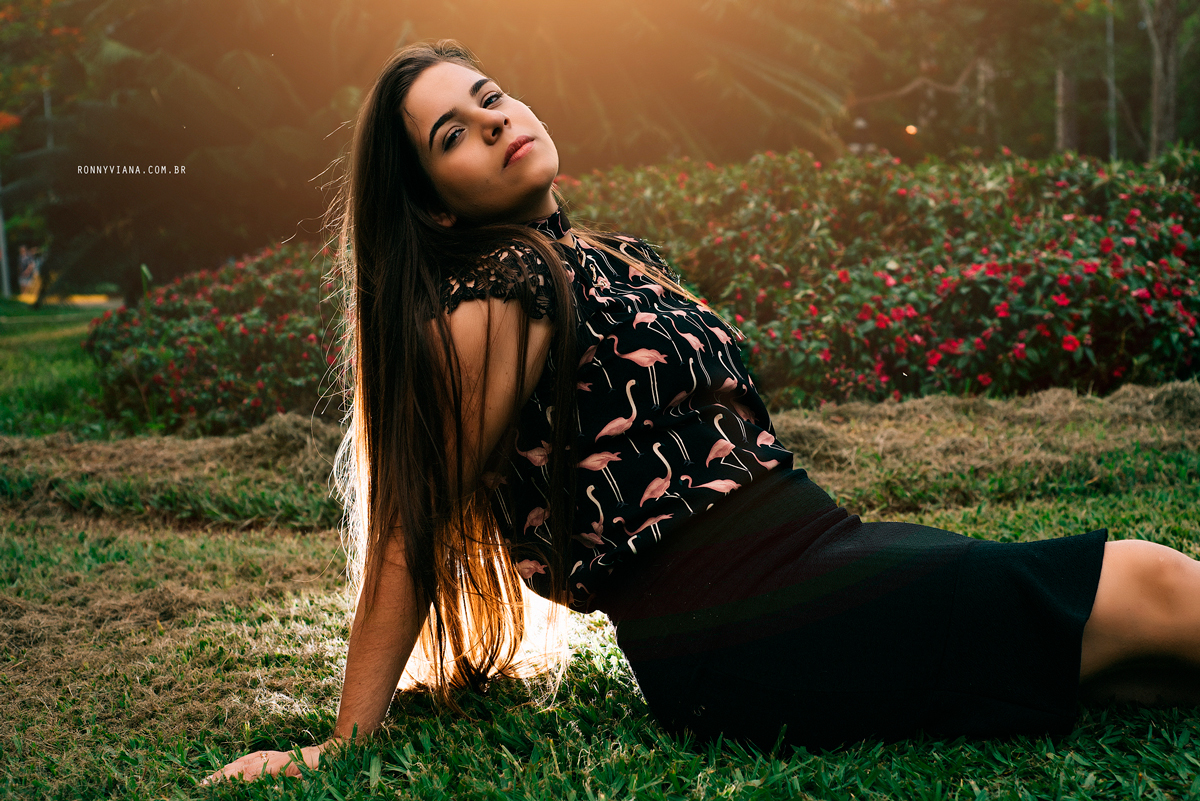 ideias para ensaios de 15 anos sentada com blusa de flamingos cabelo solto e saia preta