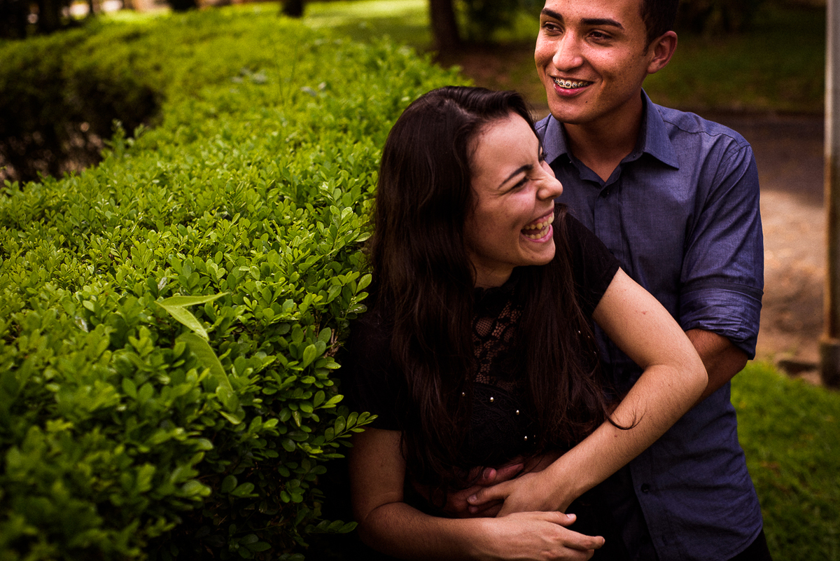 Noiva sorrindo e noivo abraçando ela momento de felicidade