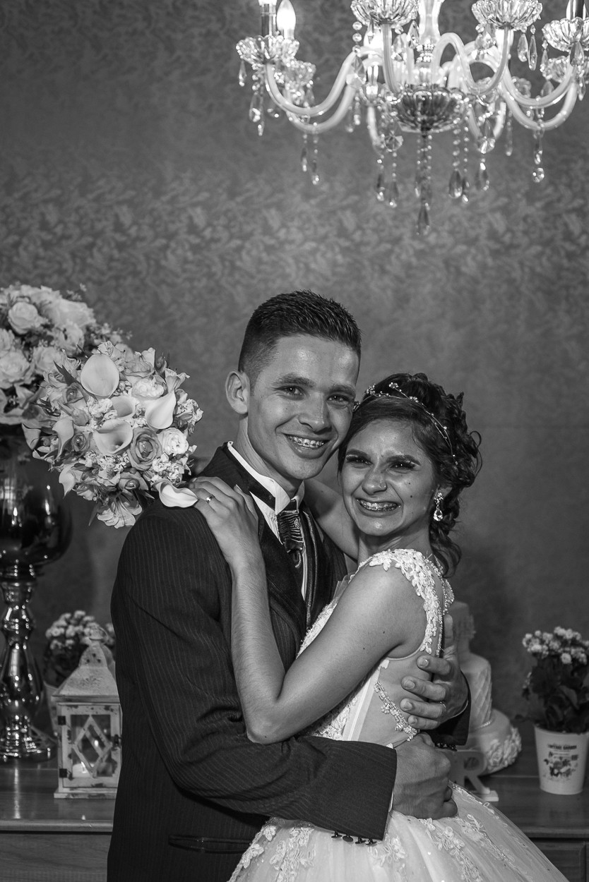 Retrato de noivos em frente a mesa decorada do bolo 