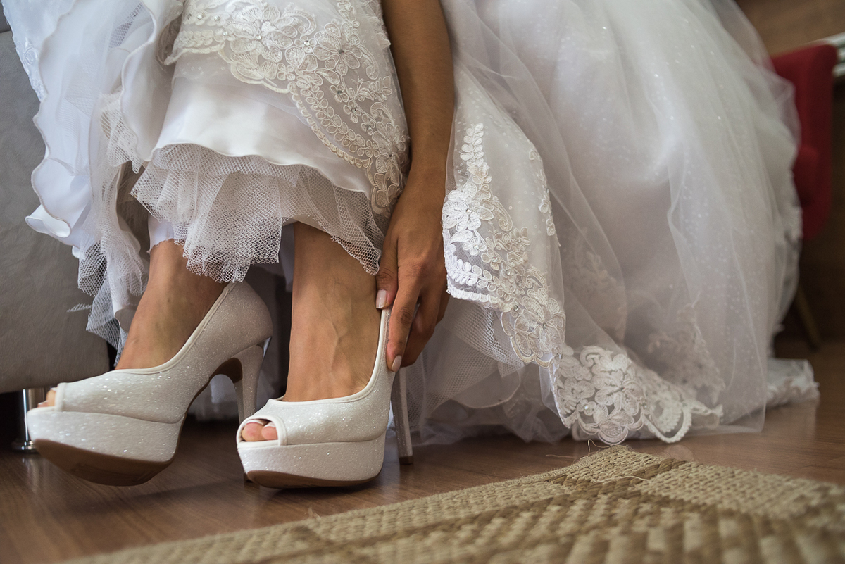 noiva colocando  Sapato Louboutin Branco para casamento