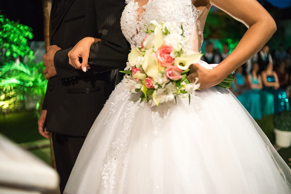 noiva segurando no noivo com o buque na mão durante a cerimonia