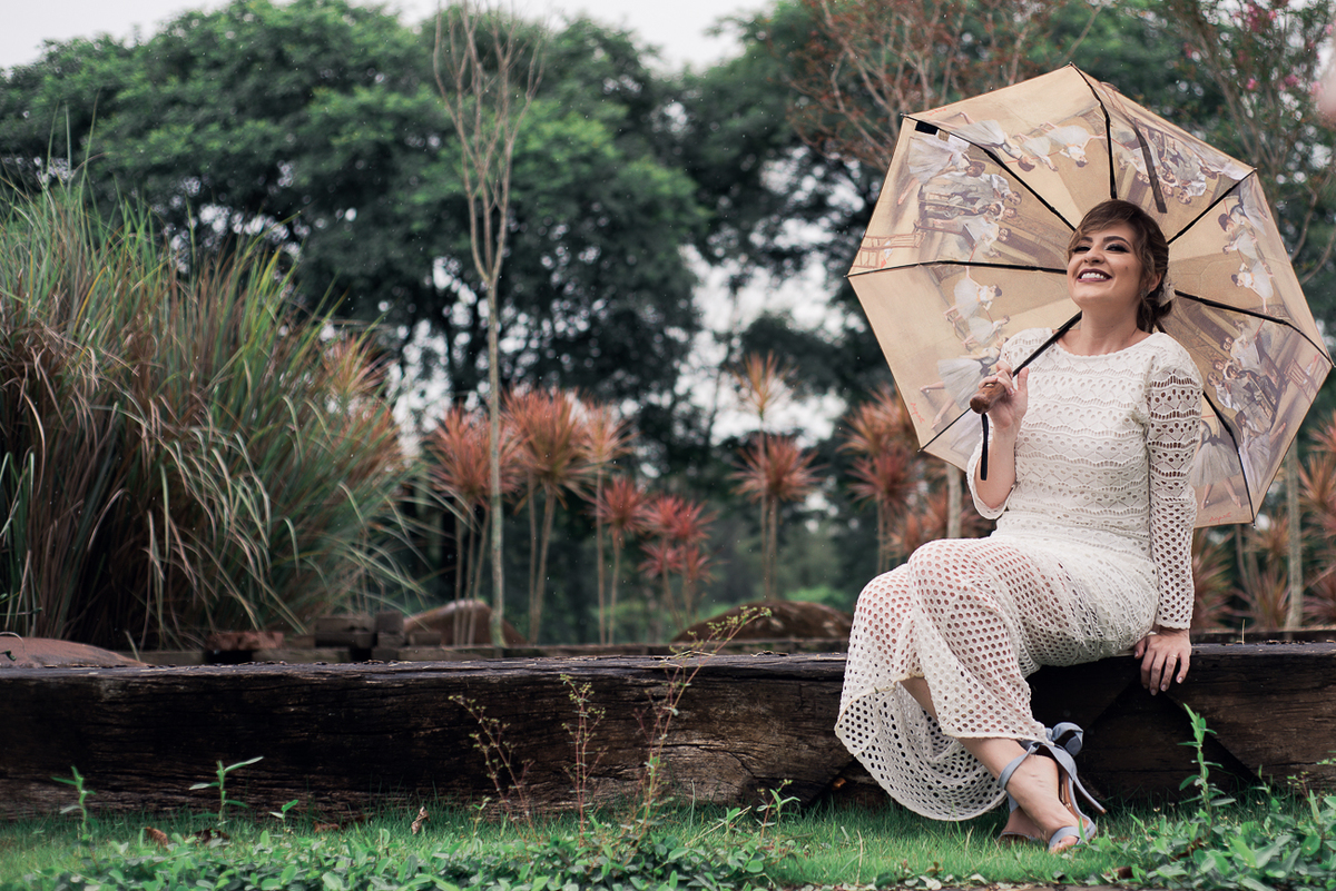 Noiva sorrindo sentada usando guarda chuva ensaio trash the dress in italy, Fotografo brasiliano in Italia