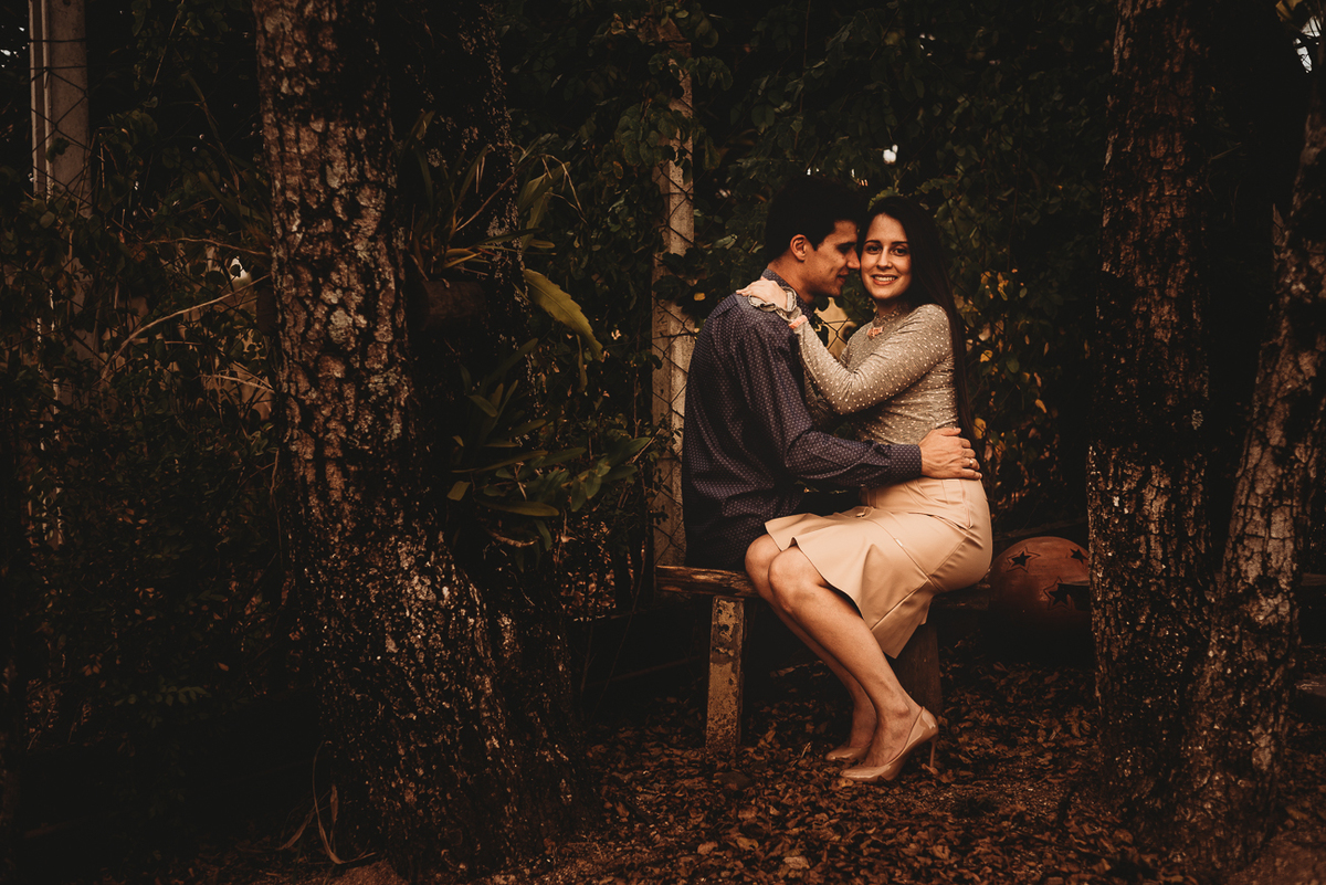 Casal sentado no banquinho apaixonados usando roupas claras para ensaio Pre wedding em Piracicaba SP