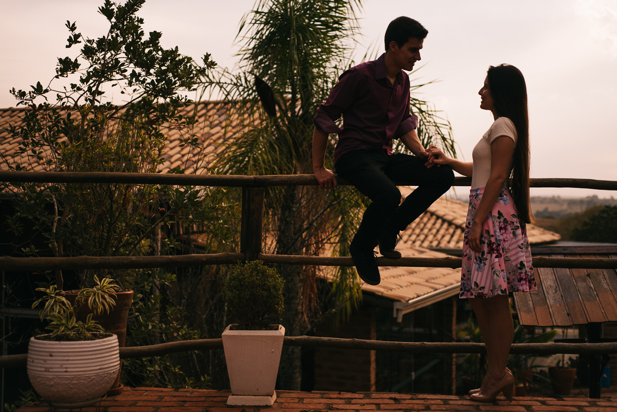 Noivo sentado no palanque e noiva de pe usando saia e blusas brancas em Piracicaba SP