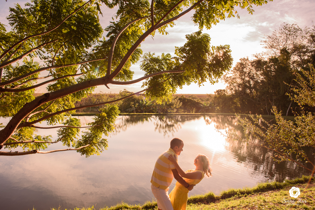 Casal de noivos, Dayene e Júnior, inclinado próximo ao lago em Dourados - MS, Sinhá Flor Fotografia