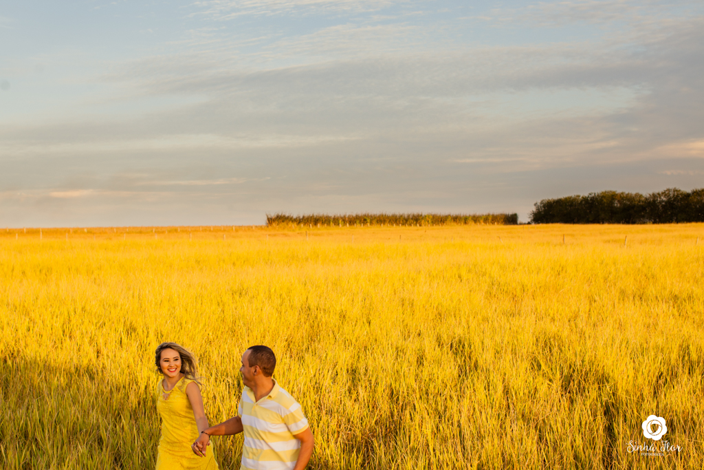 Casal de noivos, Dayene e Júnior, correndo olhando um para o outro no pasto em Dourados - MS, Sinhá Flor Fotografia