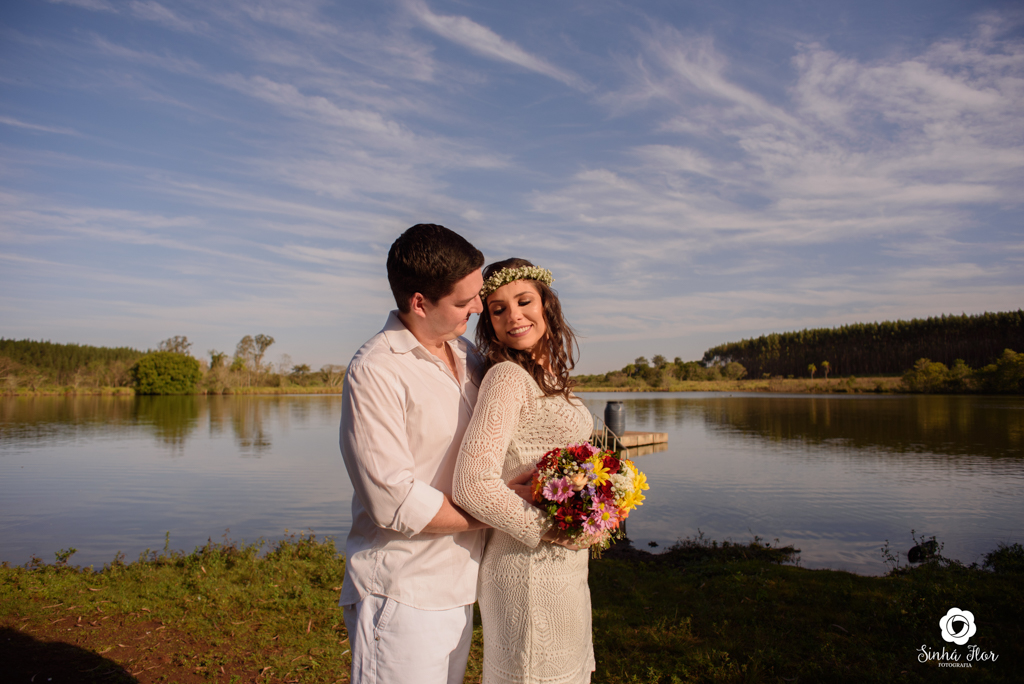 Casal de noivos, Daniele e Thiago, namorando com o buquê próximo ao lago em Dourados - MS, Sinhá Flor Fotografia