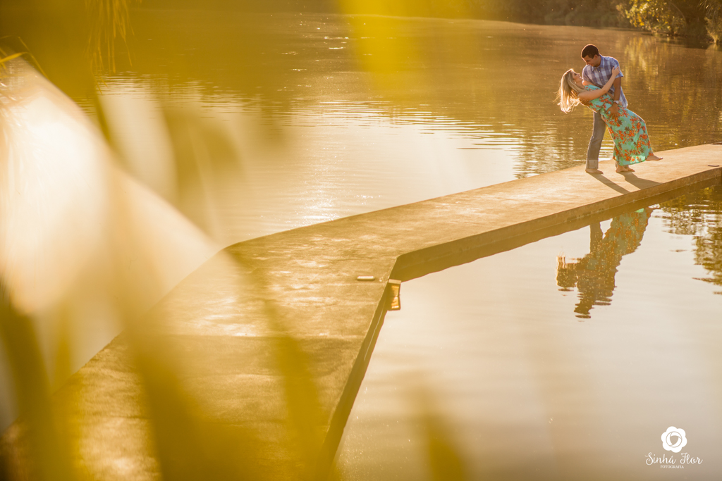 Casal de noivos, Carina e Rodolfo,  noivo deitando a noiva na passarela em Itaporã - MS, Sinhá Flor Fotografia