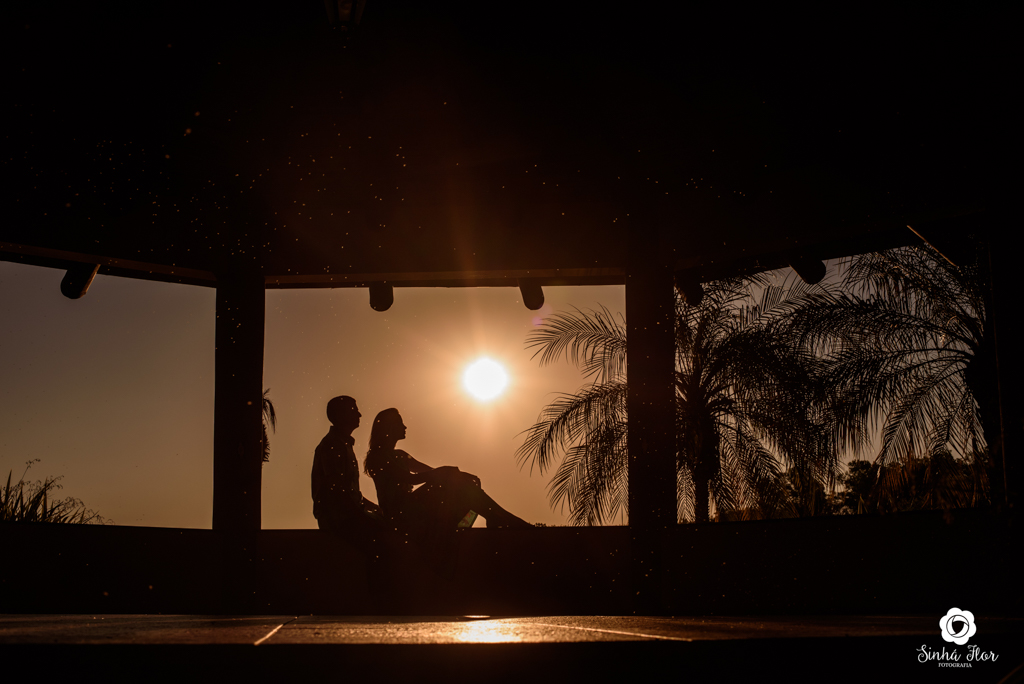 Casal de noivos, Carina e Rodolfo, silhuela noivos sentado na mureta com o pôr do sol  em Itaporã - MS, Sinhá Flor Fotografia