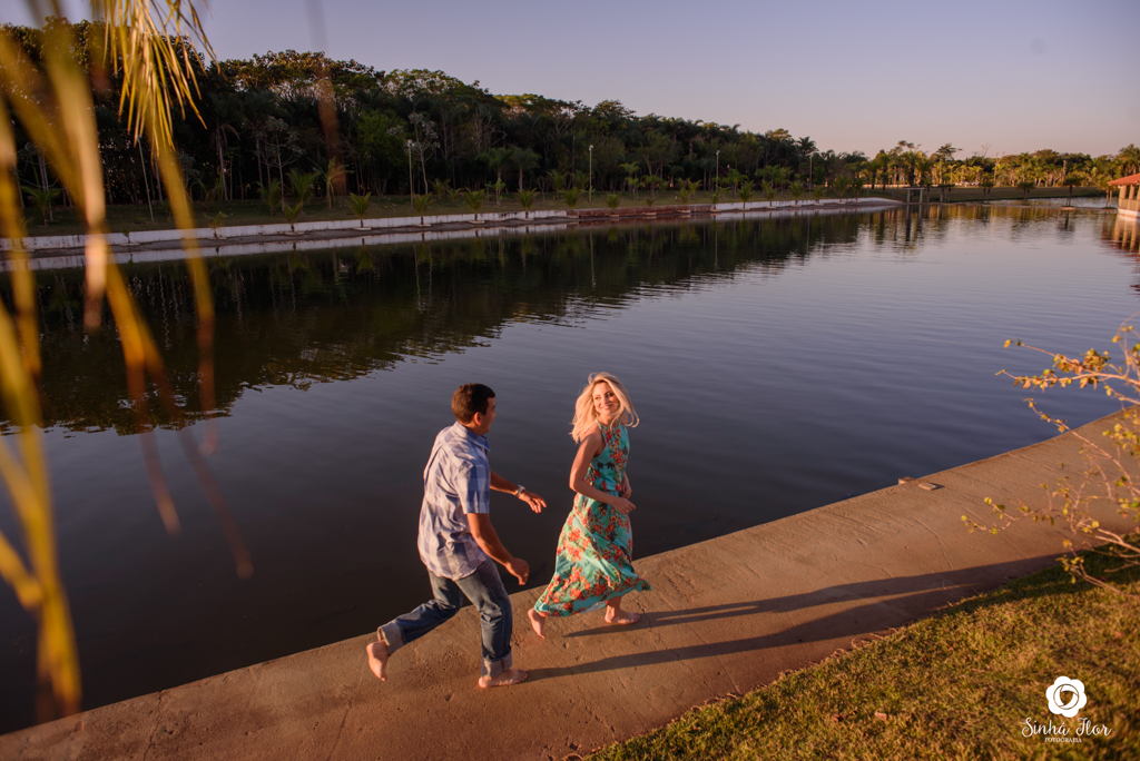 Casal de noivos, Carina e Rodolfo, noiva correndo do noivo ao fundo do lago em Itaporã - MS, Sinhá Flor Fotografia