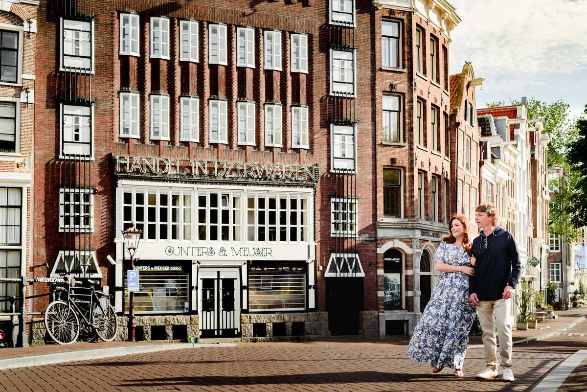 Couple during holiday in Amsterdam during Summer crossing a bridge in the Jordaan