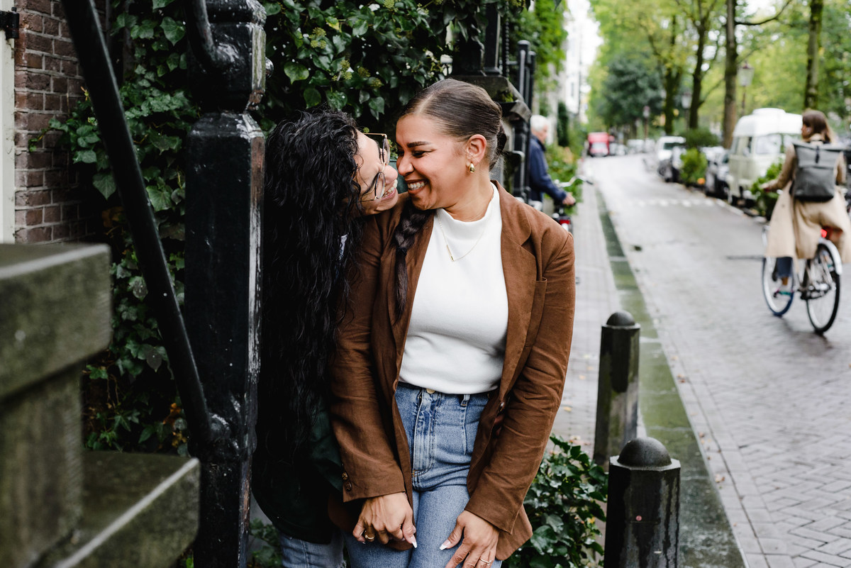 lgbtq couple laughing in front of an Amsterdam house