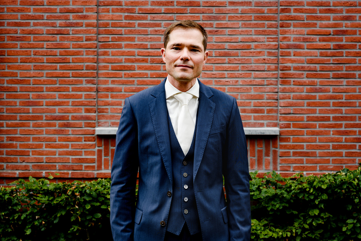 Wedding photographer in Amsterdam photographing a couple in love at gemeente Stadsloket Oost. The groom.