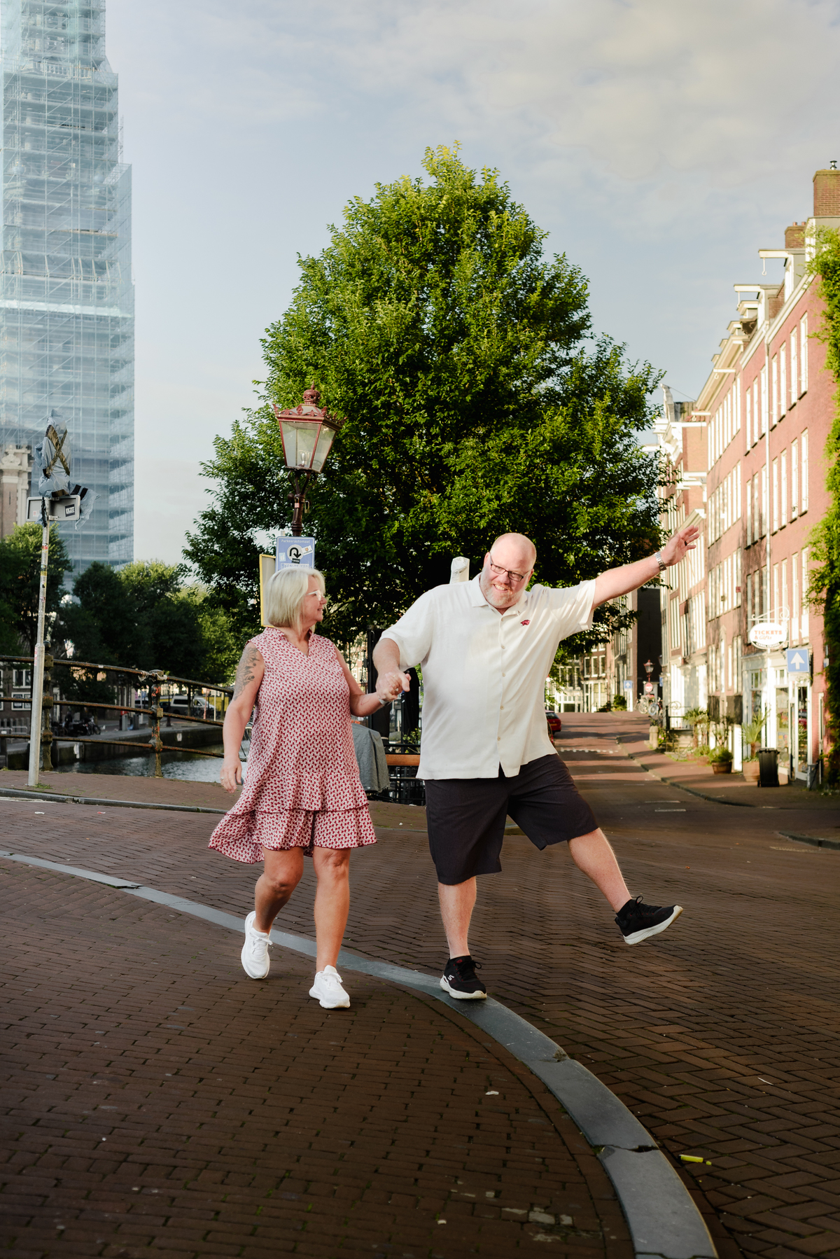 The couple sharing a playful spin by the canal, with the peaceful water and greenery creating a perfect backdrop.