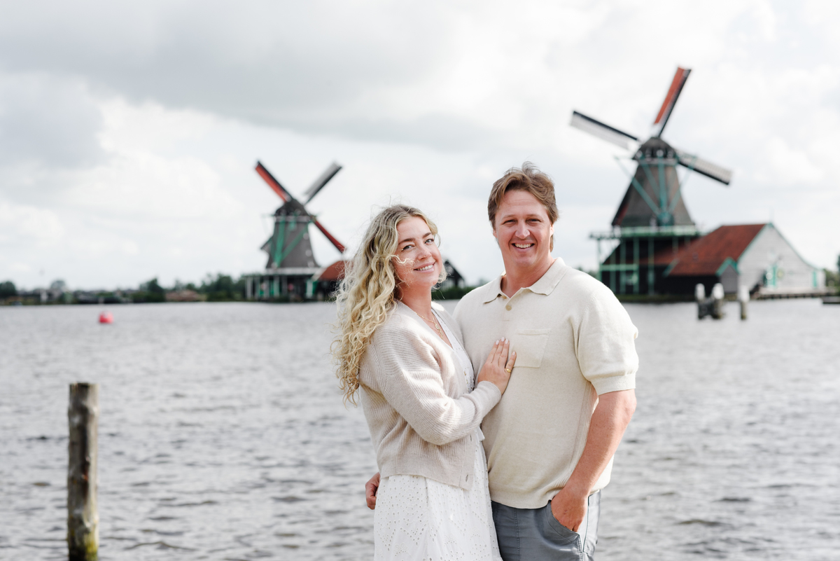 Couple standing by the water, enjoying the scenic beauty of Zaanse Schans.