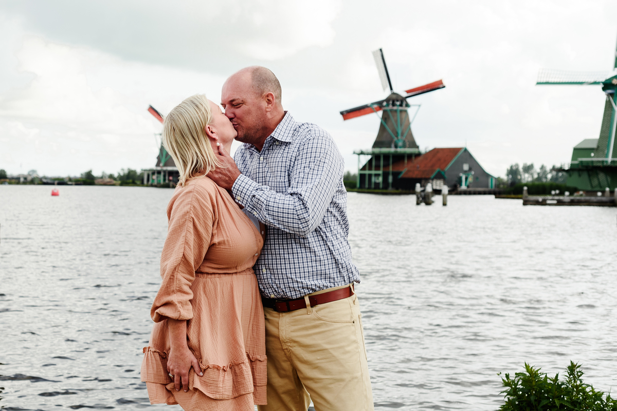 Couple standing by the water, enjoying the scenic beauty of Zaanse Schans.