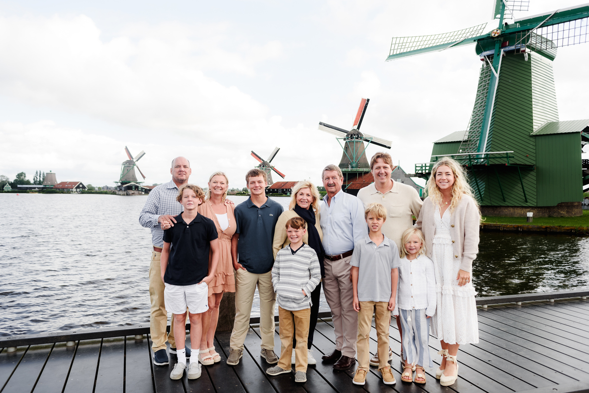 Three generations of a family enjoying a moment together with Dutch windmills in the background. Photo session in Amsterdam