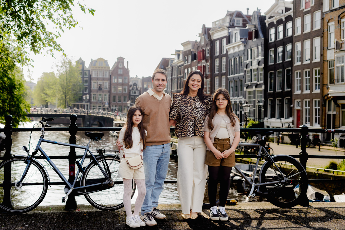 Parents and daughters enjoying a walk by the canal on a bright day.