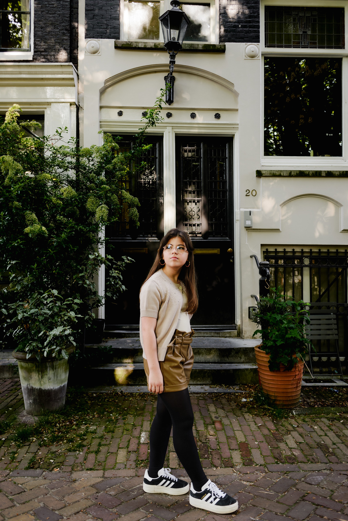 Girl posing on a quaint Amsterdam street, capturing the city’s charm.