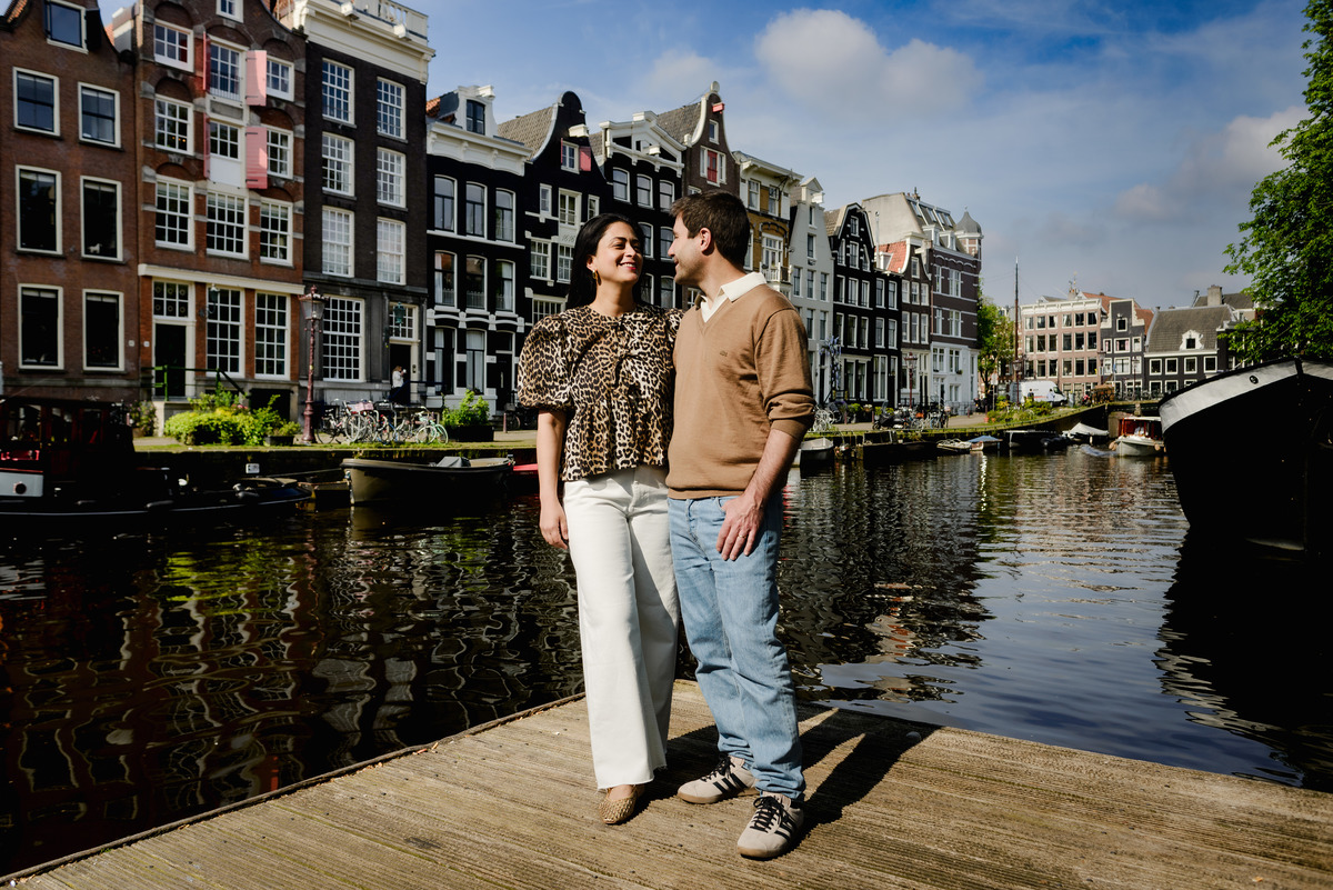 Couple on the canals of Amsterdam with historic houses as a